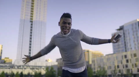 Carefree Man Listens To Music On Smartphone, Sings And Dances In City Park Stock Footage