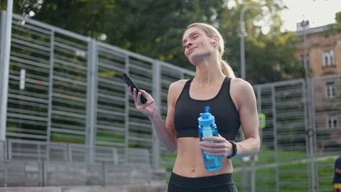 Carefree sportswoman using wireless devices for enjoying music during workout Video stock 252201021