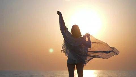 Carefree woman dancing in the sunrise on the sea beach. Vacation vitality Stock Footage
