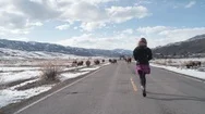 Carefree Woman Walking On The Country Road Towards Buffalo In Winter Stock Footage