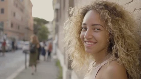 A carefree young girl standing smiling in the street on a hot summer afternoon Stock Footage