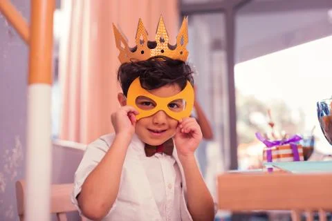 Careful boy wearing yellow mask while being at the carnival Stock Photos