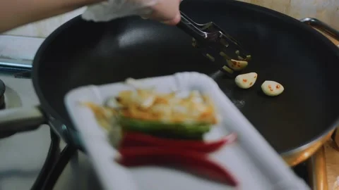 Careful culinary close-up: spooning cooked aromatics onto a white dish Stock Footage 342179582