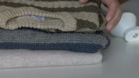 Careful hand handling of old wool sweater being restored for reuse with fabric Stock-Footage 331010448