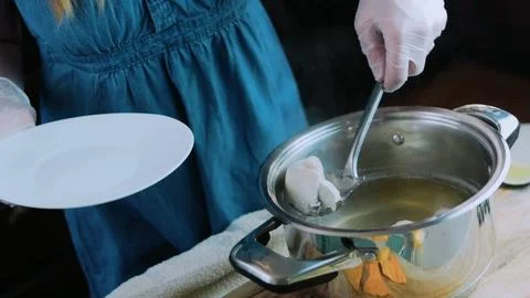Careful ingredient study: placing chicken pieces in a pot Stock Photos