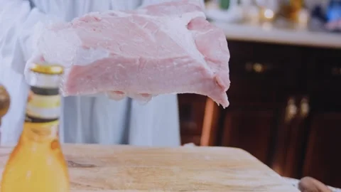 Careful precise culinary: laying pork tenderloin on a cutting board Stock Footage 342184336