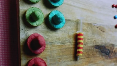 Careful serving sequence of placing a rounded crown on a red cookie brim Stock Footage 342155785
