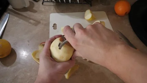 Carefully peeling an apple within a kitchen environment setting Stock Footage 317052000