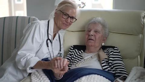 Caregiver Sharing a Warm Moment With Elderly Woman at Home Visit Stock Footage 310501087