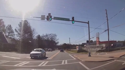 Careless distracted driver runs red traffic light and narrowly escapes Stock Footage