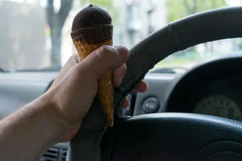Careless driver keeps ice cream behind the wheel of the car Stock Photos
