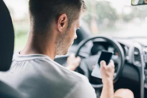 Careless driver using a mobile phone whilst driving Stock Photos