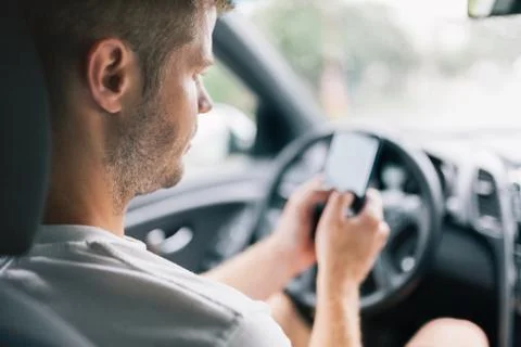 Careless driver using a mobile phone whilst driving Stock Photos