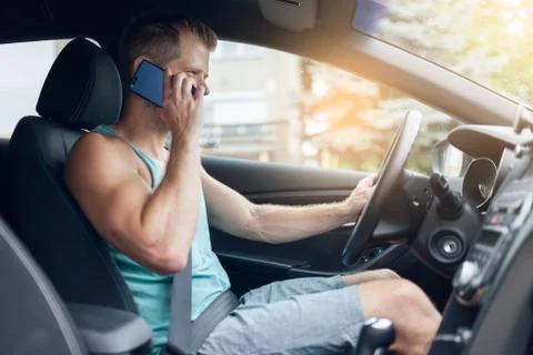 Careless driver using a mobile phone whilst driving Foto stock