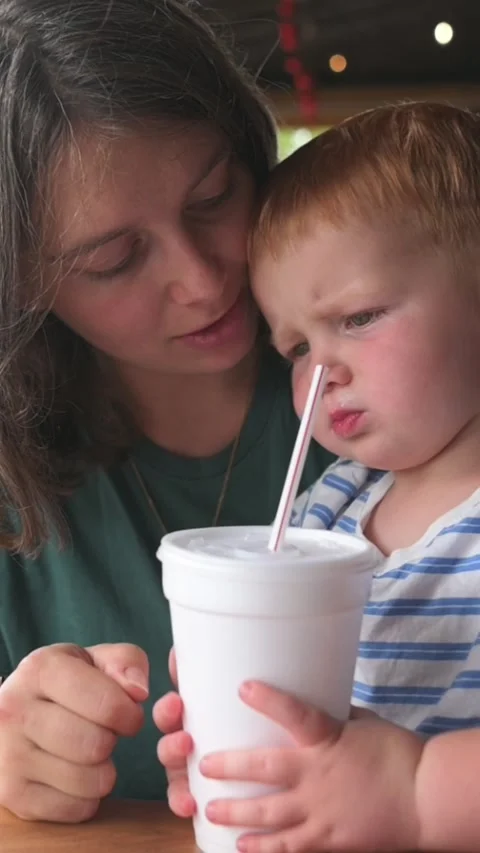 Caretaker teaches young learner, parent and child together at cafe learning Stockbeeldmateriaal 323093725