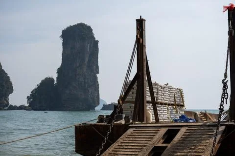 Cargo barge with limestone sea stack background 库存照片