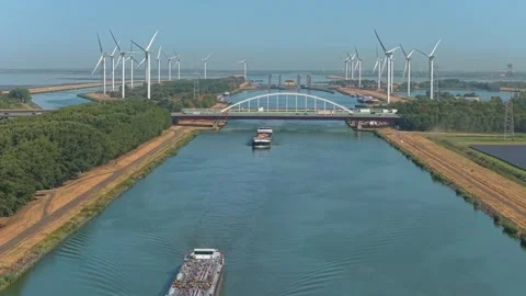 Cargo barge navigating scheldt rhine canal with wind turbines 스톡 동영상 345027034