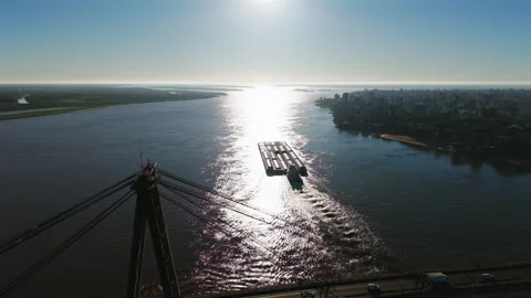 Cargo barge sailing past the General Belgrano Bridge on the Paraná River near Vídeos de archivo 322182921