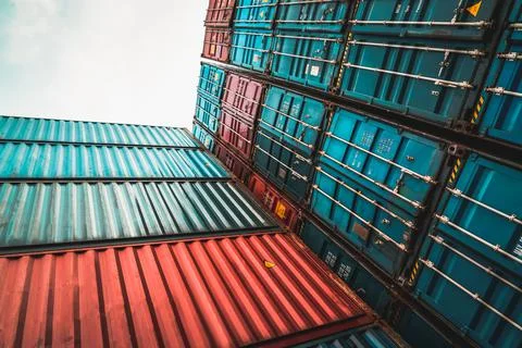 Cargo container for overseas shipping on high stack look up from ground Foto stock