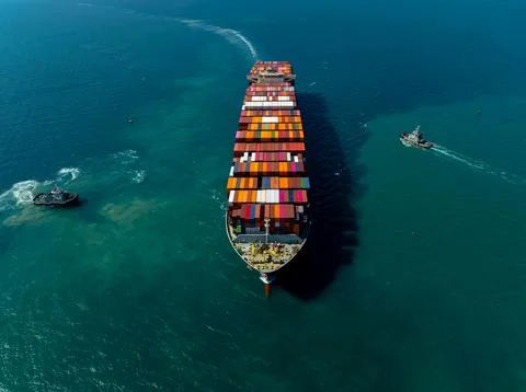 Cargo Container Ship Navigating Open Sea Escorted By Tugboats High Angle View 스톡 사진