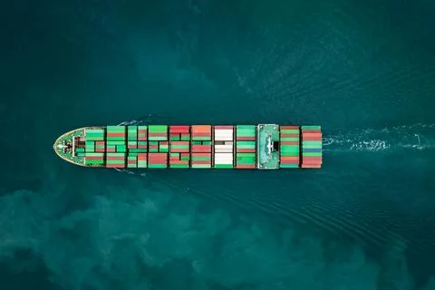 Cargo Container Ship Navigating In Turquoise Ocean Waters Overhead View Stockfoto's