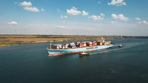 Cargo container ship is sailing to port for unloading accompanied by pilots Stock Footage 160366613