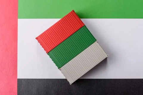 Cargo container on the uae flag as a conceptual backdrop for goods export. .. Stock Photos