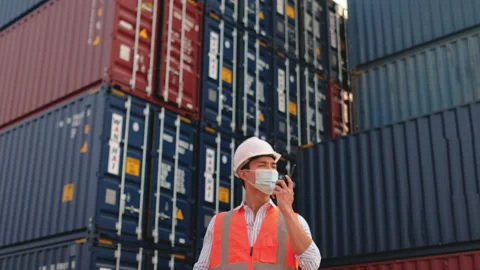 Cargo container worker with face mask use walkie talkie to communicate Stock Footage 146461559