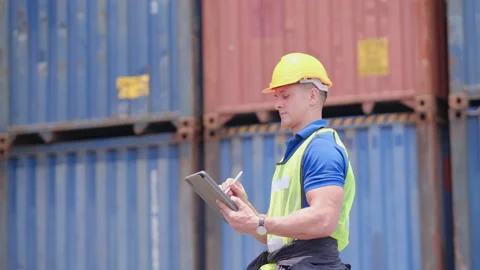 Cargo container worker or foreman look around and use tablet Stock-Footage 146714035