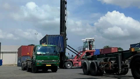 Cargo containers are being loaded onto a truck at a port using a large crane Stock Footage 299622137