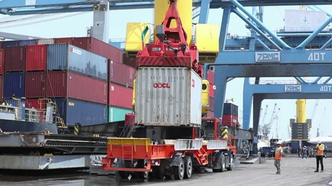 Cargo containers being loaded onto trucks at the busy shipping port Stock Footage 318201048