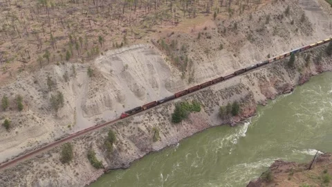 Cargo Containers Rolling Along Cliffside Rail Beside Green Fraser Canyon Water Stock Footage 345983587