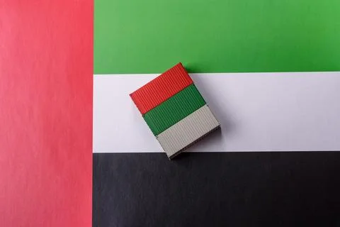 Cargo containers on the UAE flag as a conceptual backdrop for goods export... Stock Photos