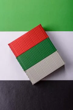 Cargo containers on the UAE flag as a conceptual backdrop for goods export... Stock Photos
