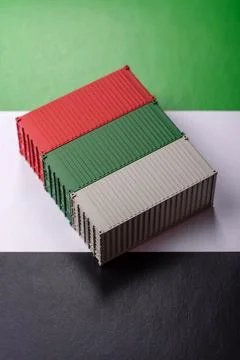 Cargo containers on the UAE flag as a conceptual backdrop for goods export... Stock Photos
