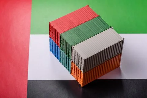 Cargo containers on the UAE flag as a conceptual backdrop for goods export... Stock Photos