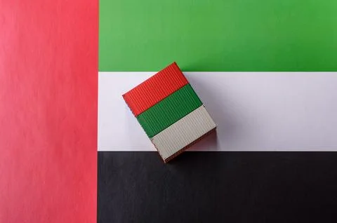 Cargo containers on the UAE flag as a conceptual backdrop for goods export... Stock Photos