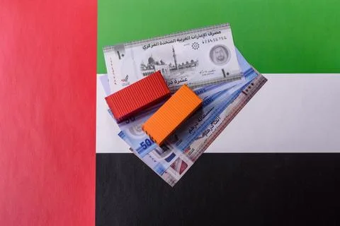 Cargo containers on the UAE flag as a conceptual backdrop for goods export... Stock Photos