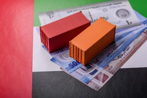 Cargo containers on the UAE flag as a conceptual backdrop for goods export... Stock Photos