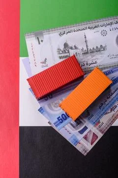 Cargo containers on the UAE flag as a conceptual backdrop for goods export... Stock Photos
