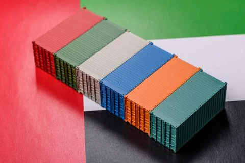 Cargo containers on the UAE flag as a conceptual backdrop for goods export... Stock Photos
