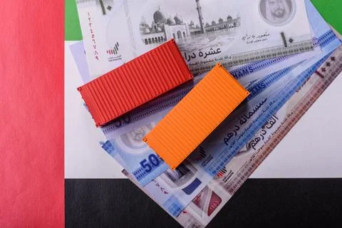 Cargo containers on the UAE flag as a conceptual backdrop for goods export... Stock Photos