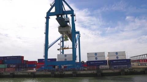 A cargo crane grabs a container for loading onto a ship. Stock Footage 284720904