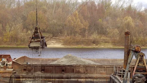 A cargo crane loads sand onto a barge Stock Footage 118244714