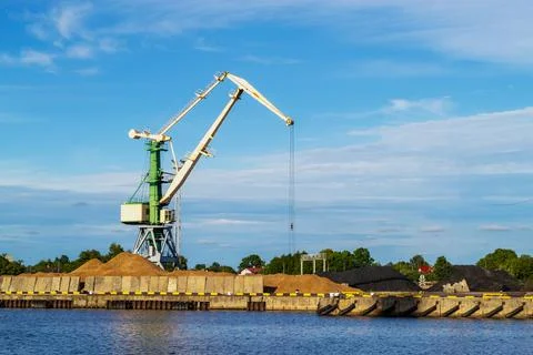 Cargo crane in terminal in river. Storage, port cranes, industrial scene. Stock Photos