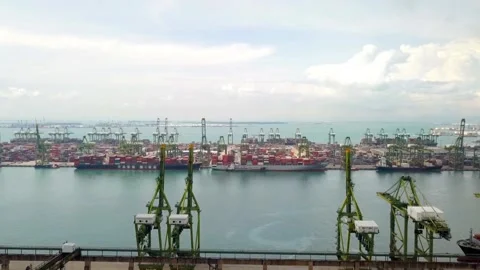 Cargo cranes and containers fill the singapore port on a cloudy day 動画素材 312432586