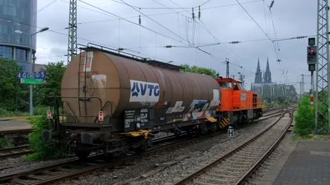 Cargo freight train with tank car and orange locomotive on industrial tracks Vídeo Stock 337405140