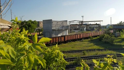 Cargo freight train wagons go on railroad in industrial zone with plants and Stock Footage 90527680