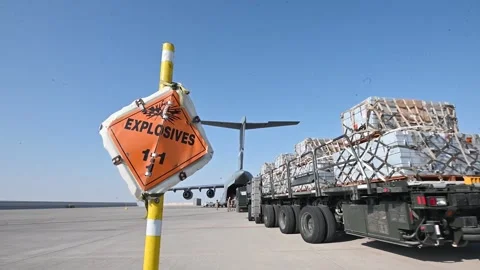 Cargo loader delivering pallets of explosives to C-17 Globemaster III Stock Footage 256895820