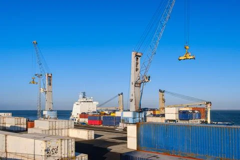 Cargo port busy with loading a bulk carrier, port and deck cranes working Stock Photos